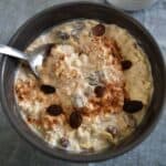 Cinnamon raisin overnight oats in a bowl with a spoon.