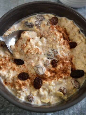 Cinnamon raisin overnight oats in a bowl with a spoon.