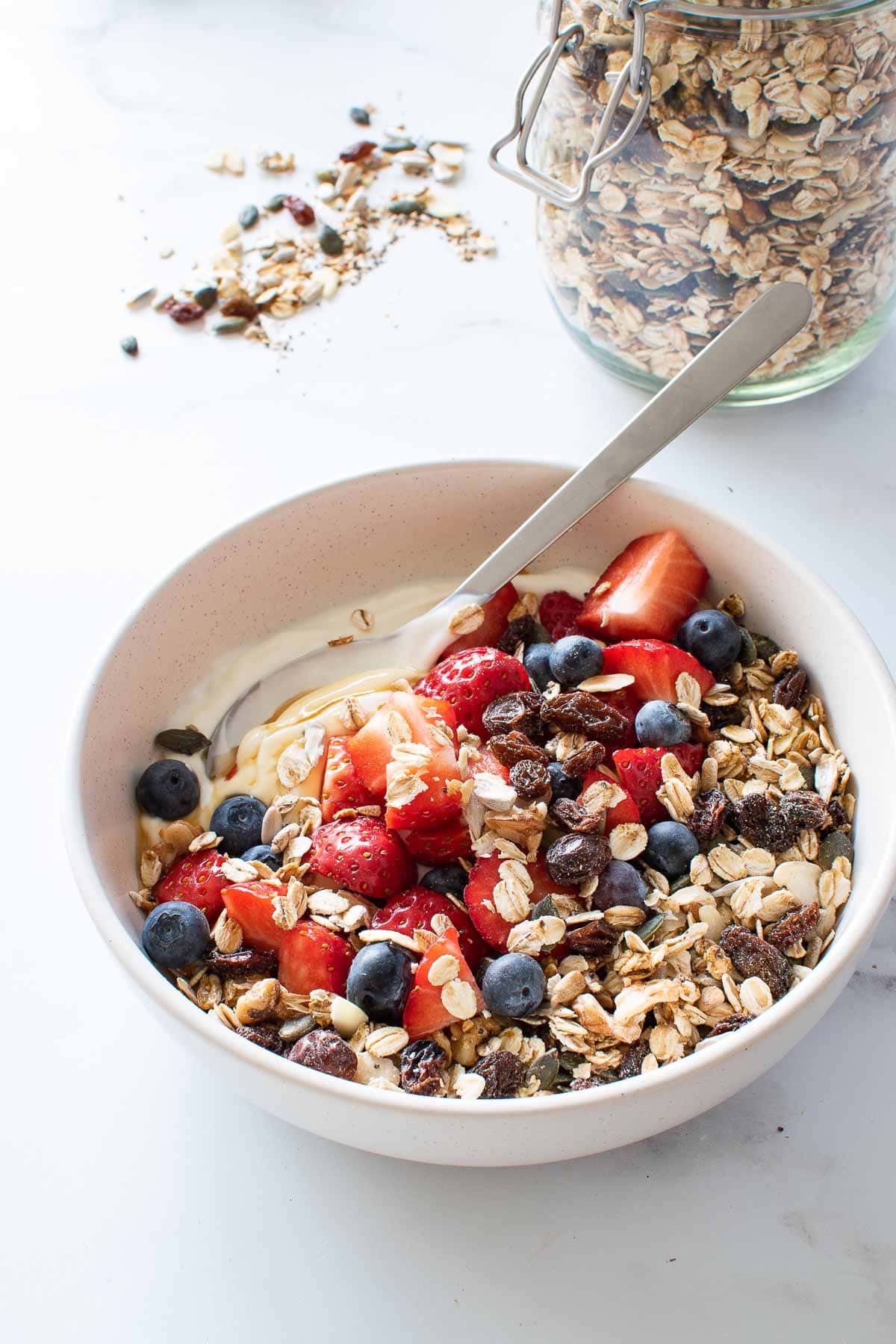 Toasted muesli in a bowl with yogurt and mixed berries.
