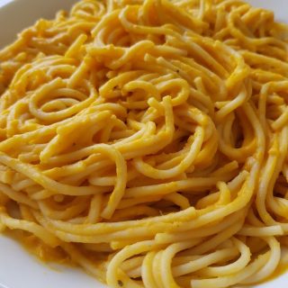 Close up of butternut squash pasta sauce on spaghetti.