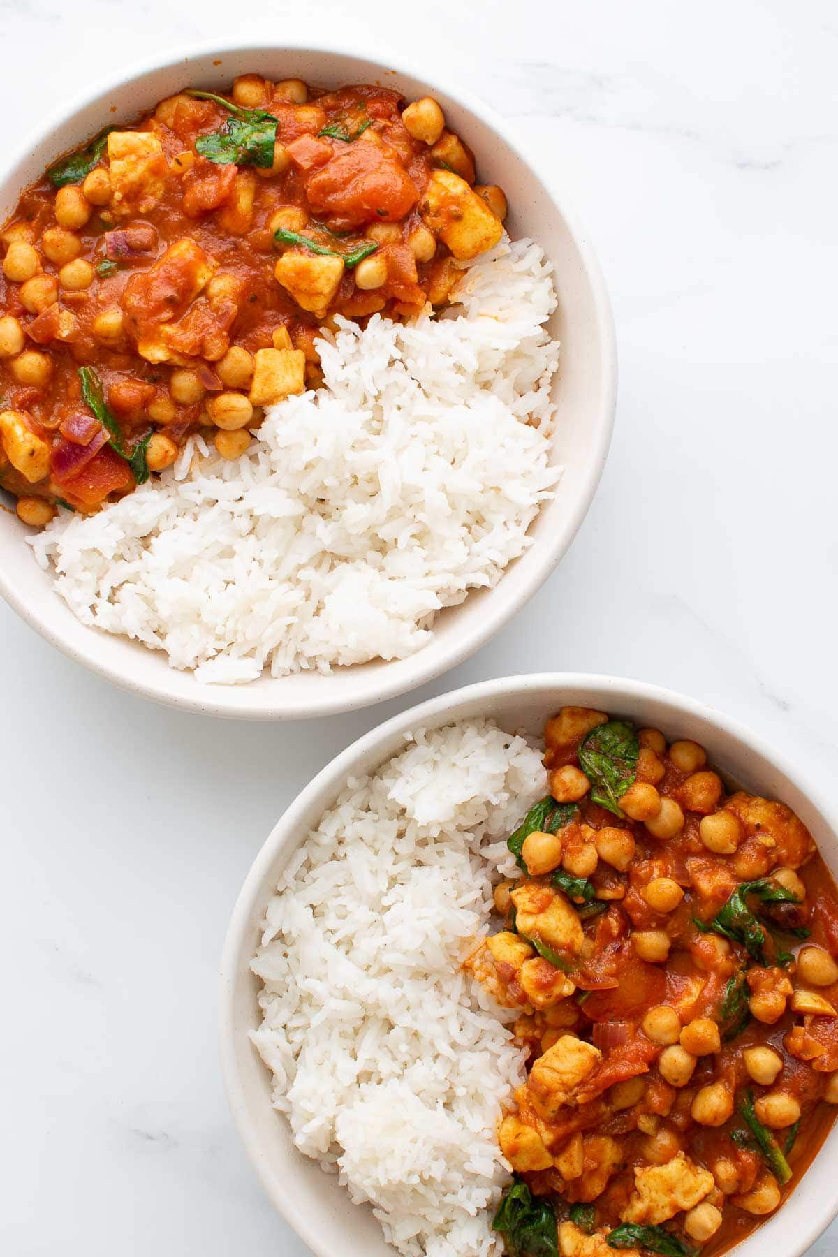 Two bowls of chickpea curry with rice.