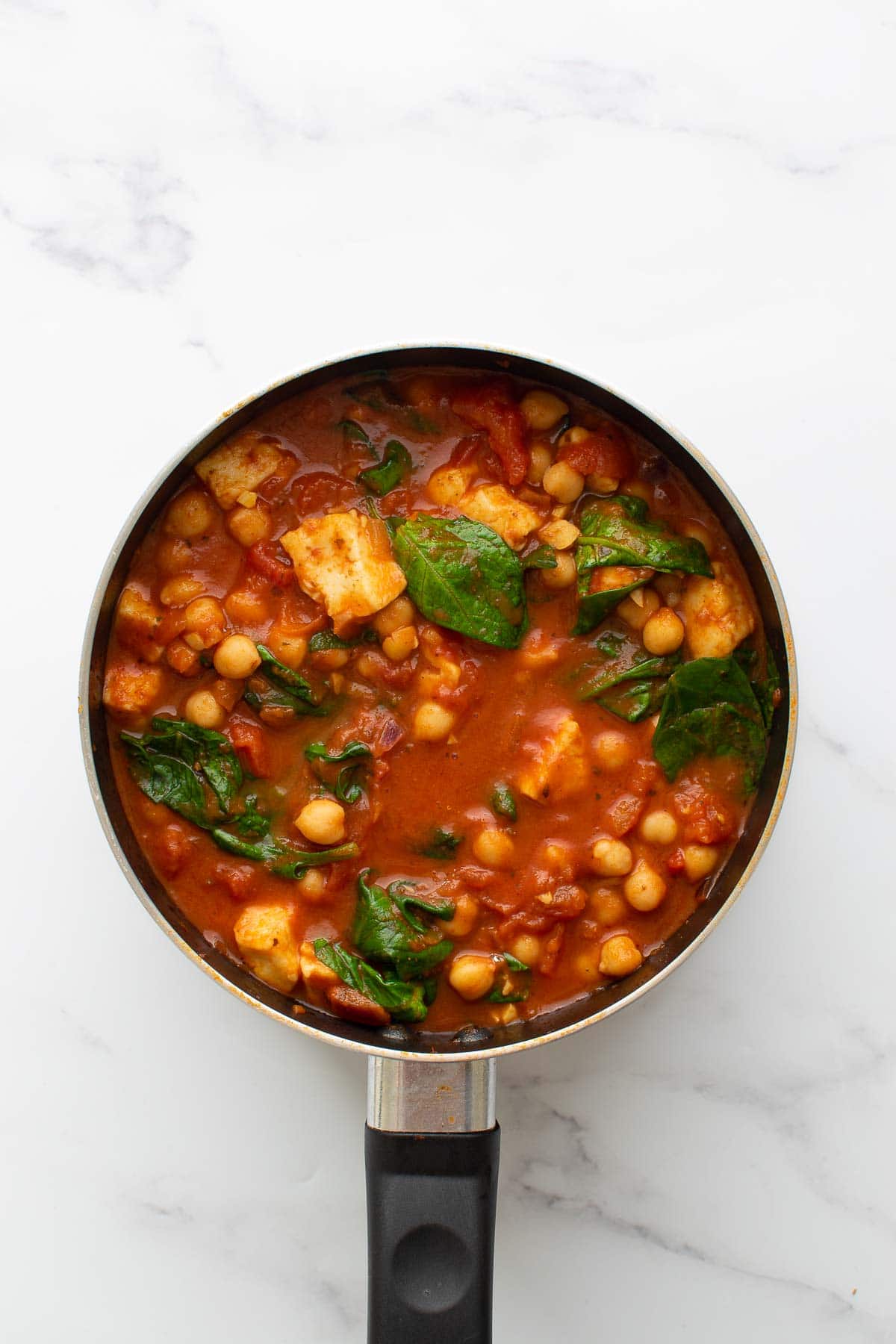 Halloumi and spinach curry in a pot.