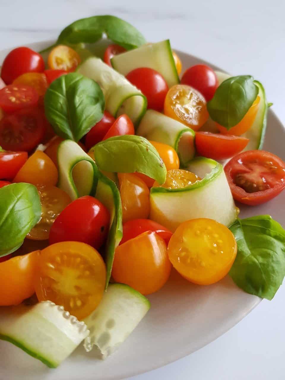 Cucucmber and tomato salad on a grey plate.