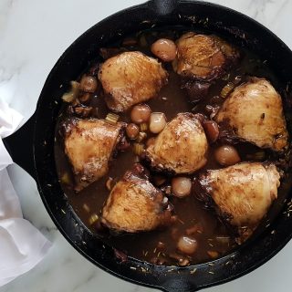 coq au vin in a cast iron pan.