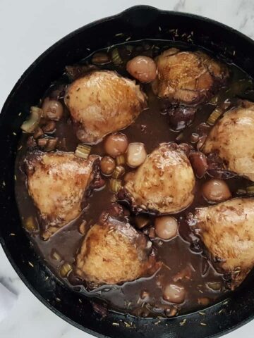 Coq au vin in a cast iron pan.