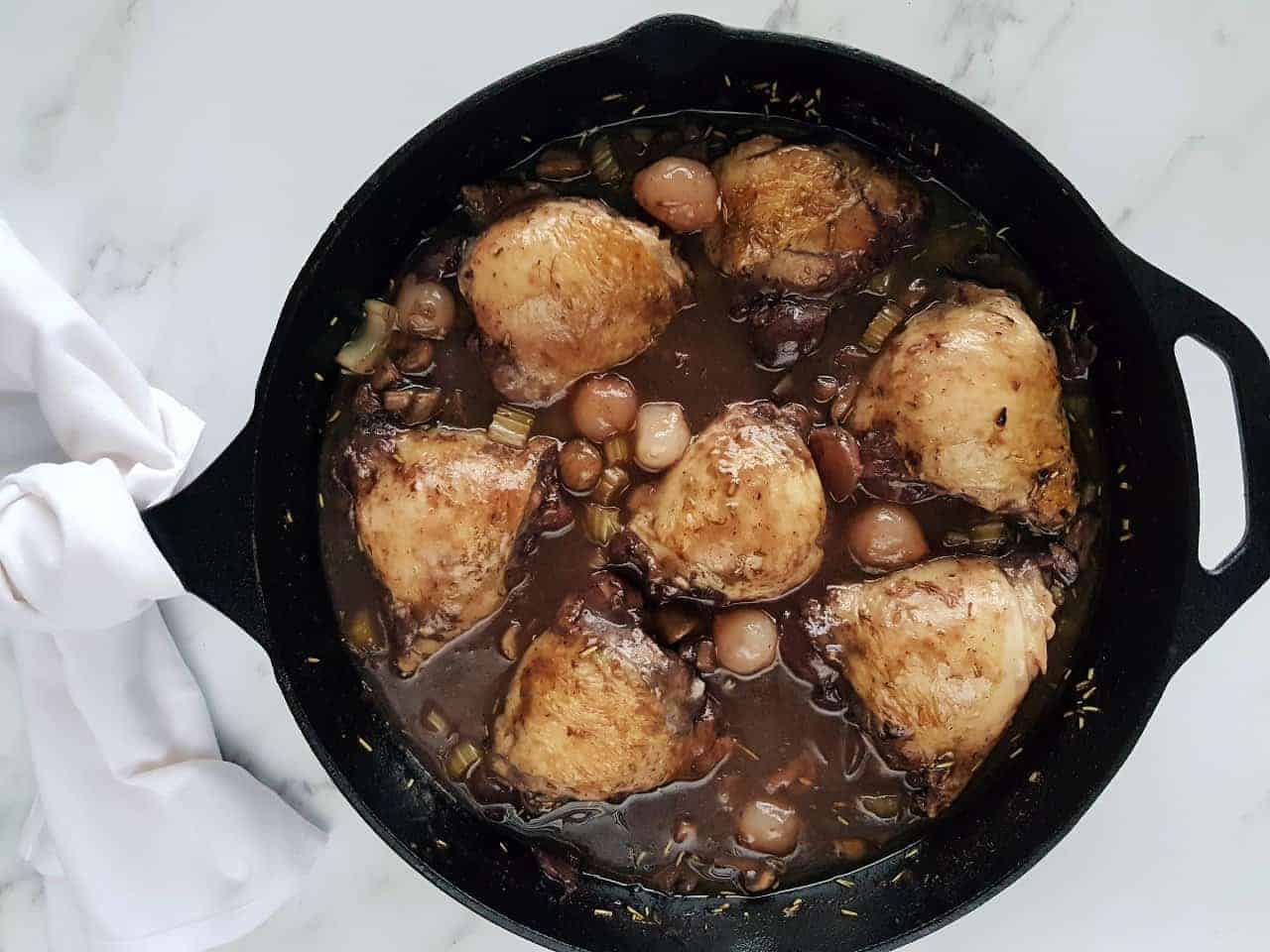Coq au vin in a cast iron pan.