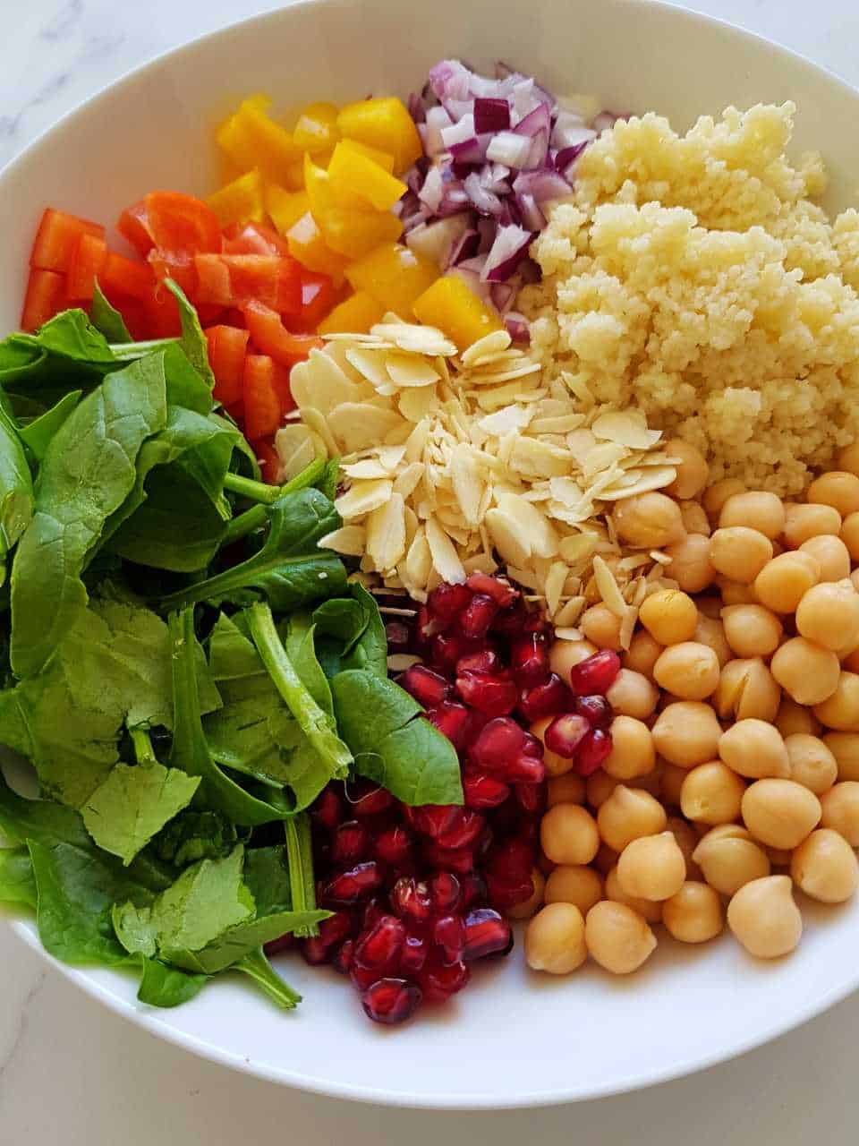 Couscous salad ingredients in a white bowl - not mixed together.