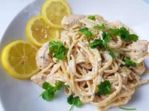 Creamy lemon chicken pasta on a white plate.
