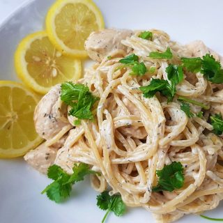 Creamy lemon chicken pasta on a white plate.