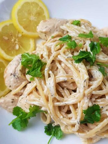 Creamy lemon chicken pasta on a white plate.