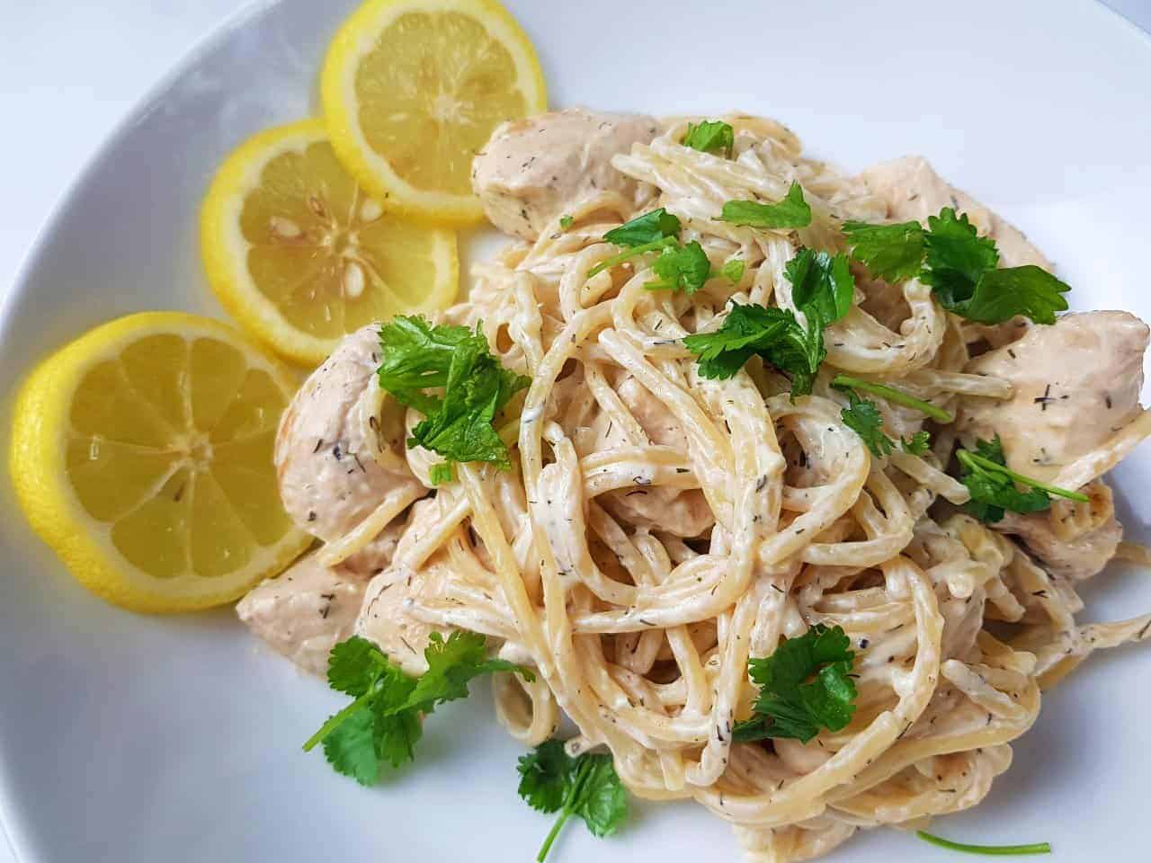 Creamy lemon chicken pasta on a white plate.