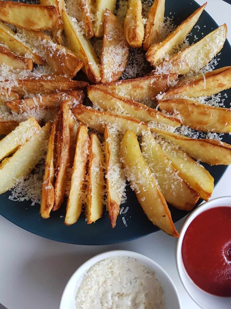 A large plate of garlic parmesan potato wedges.