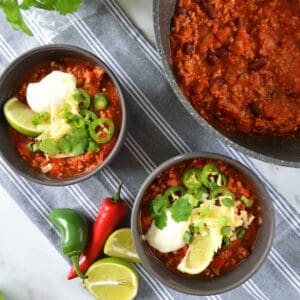 One pot turkey chili in a large pot, with two bowls served on the side.