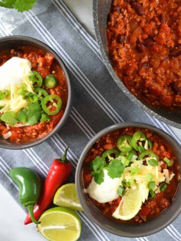 One pot turkey chili in a large pot, with two bowls served on the side.