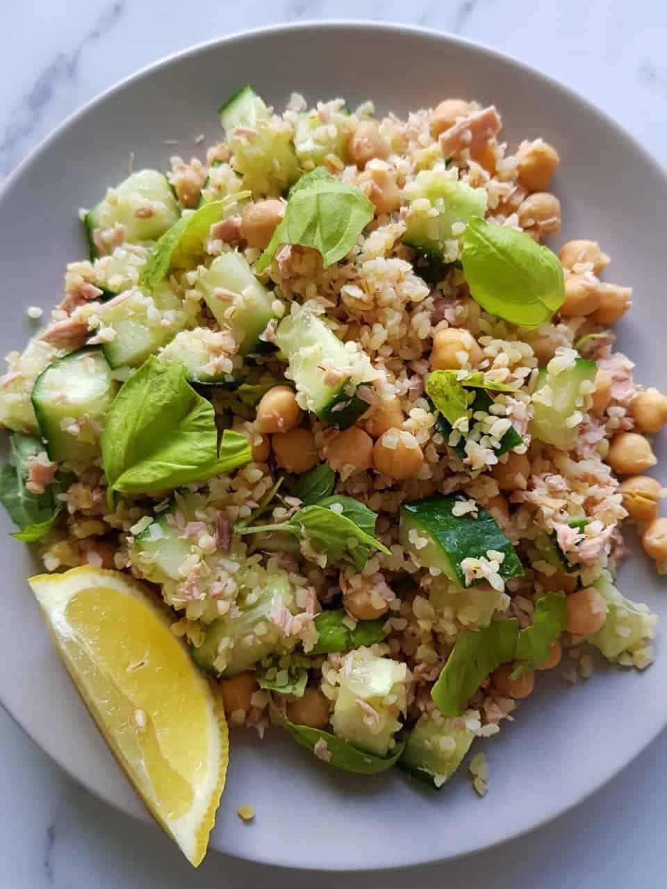 Tuna bulgur salad on a plate with a slice of lemon on the side.