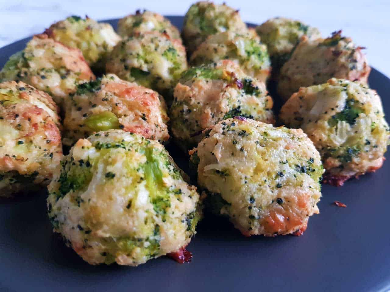 Broccoli and cheese balls on a gray plate.