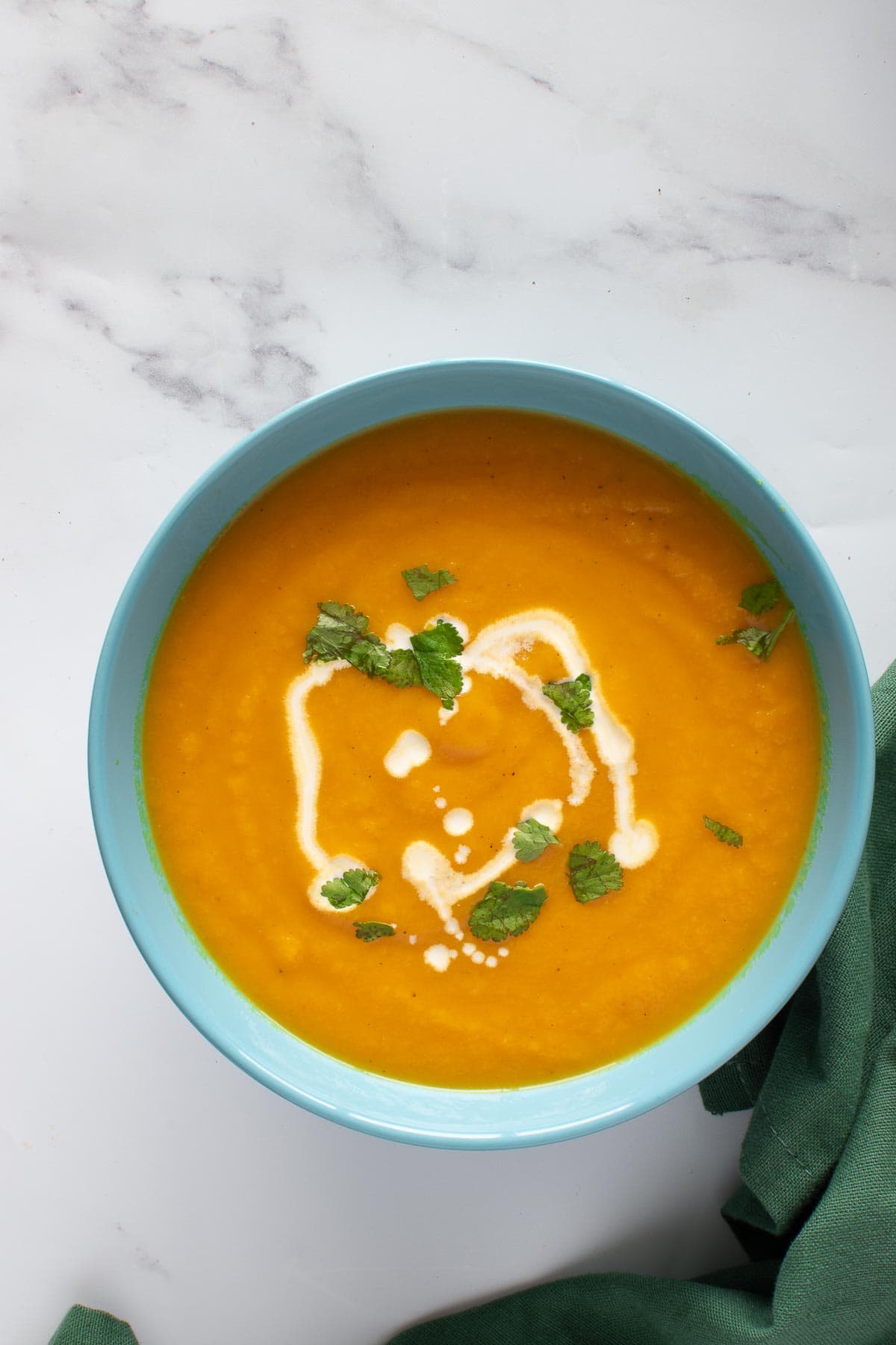 A bowl of carrot and ginger soup on a table.