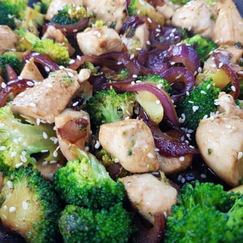 Chicken and broccoli stir fry in a black pan.