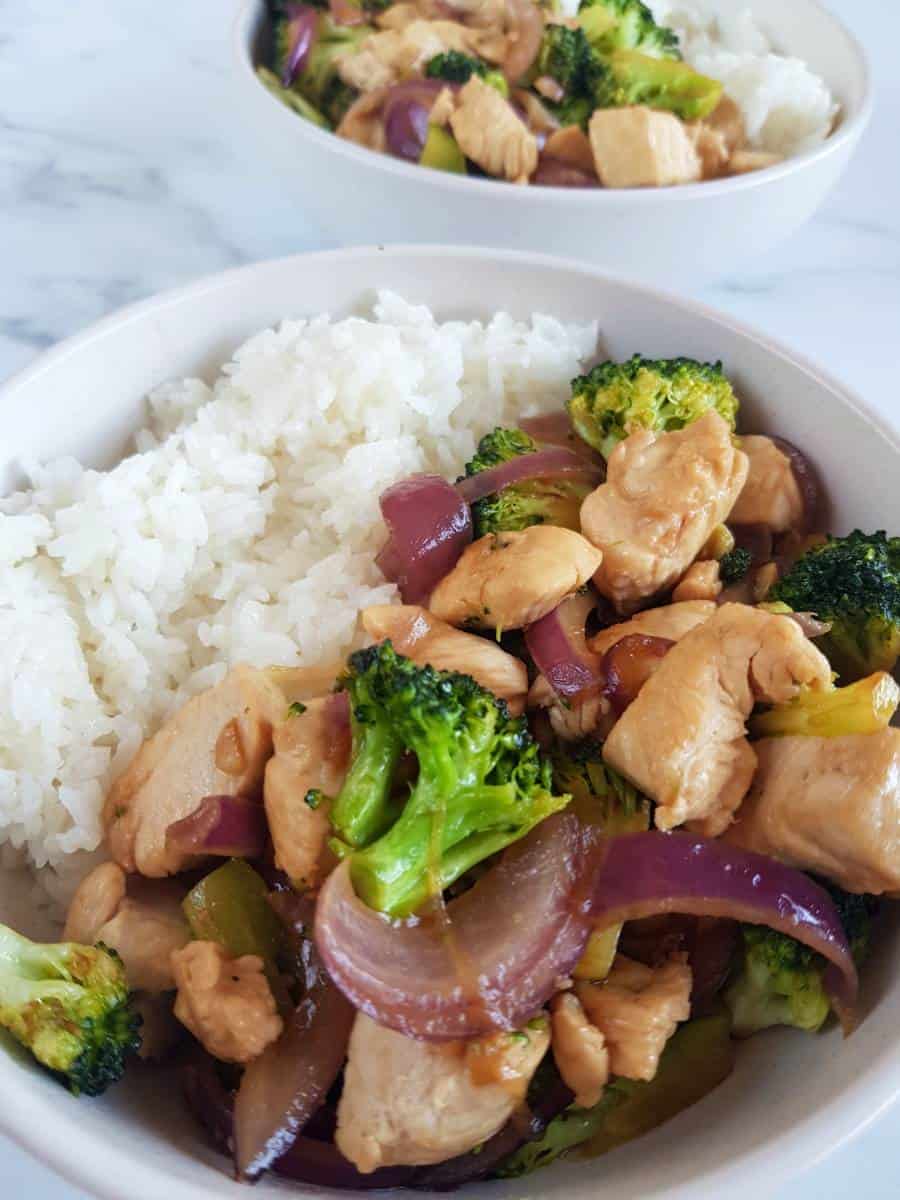 Chicken and broccoli stir fry with rice in bowls.