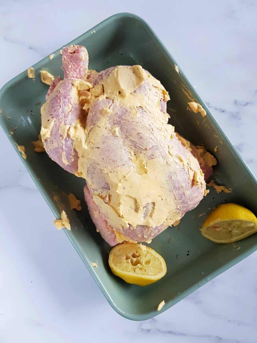 Chicken with butter in a baking dish.