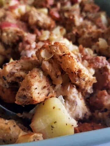 Sausage apple stuffing in a green casserole dish.