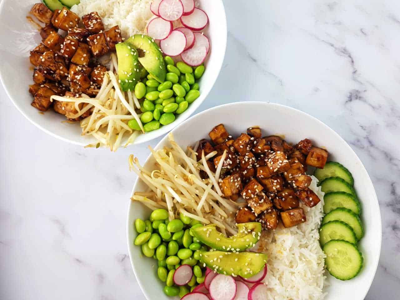 Teriyaki tofu in white bowls on a marble table.