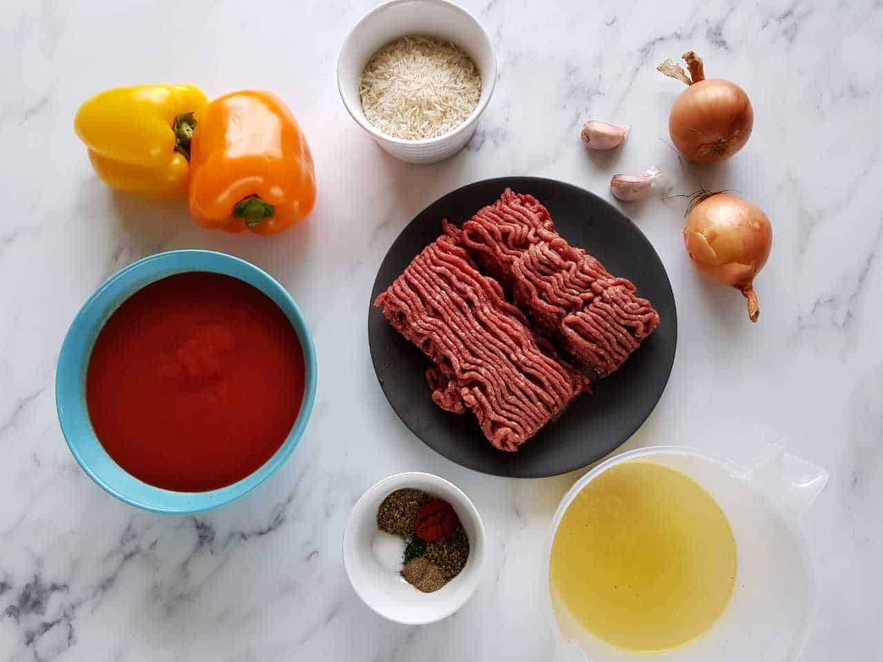 Ingredients for stuffed pepper soup laid out on a marble table.