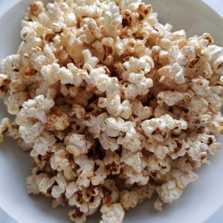 Popcorn with honey and cinnamon in a white bowl.