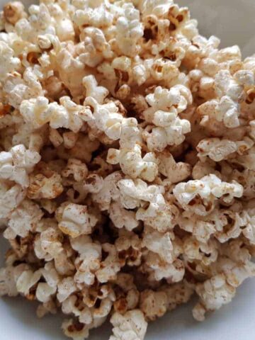 Popcorn with honey and cinnamon in a white bowl.