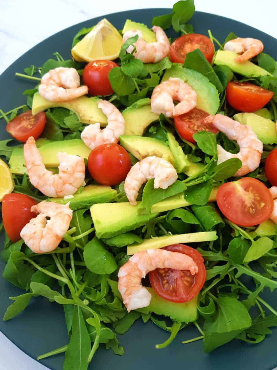 Shrimp avocado salad on a blue plate.