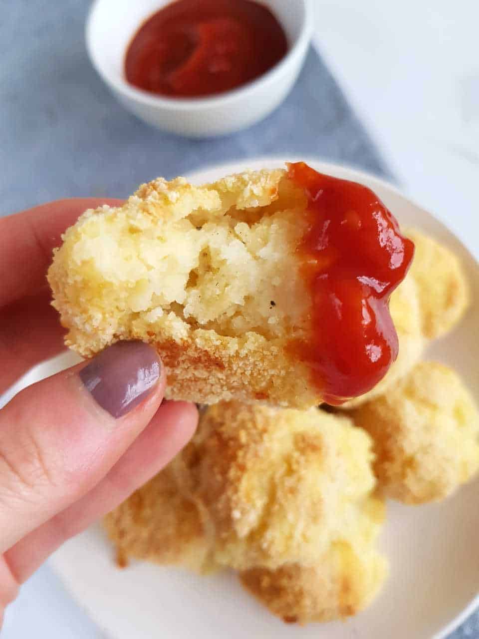 Cheesy mashed potato balls dipped in ketchup.