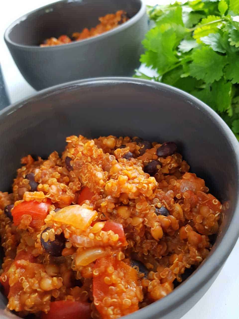 Quinoa and black bean chili in gray bowls.