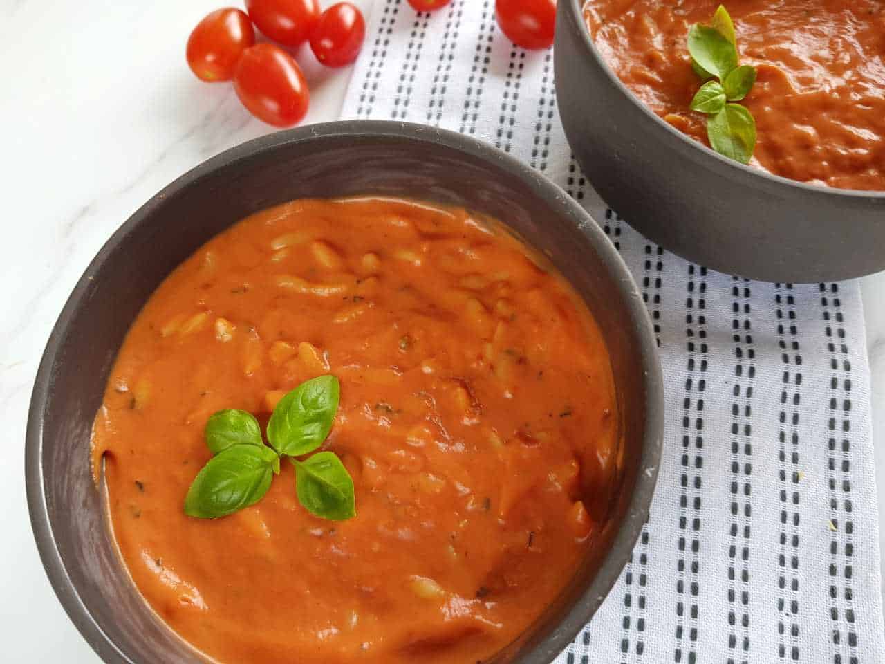 Tomato soup with pasta in gray bowls.