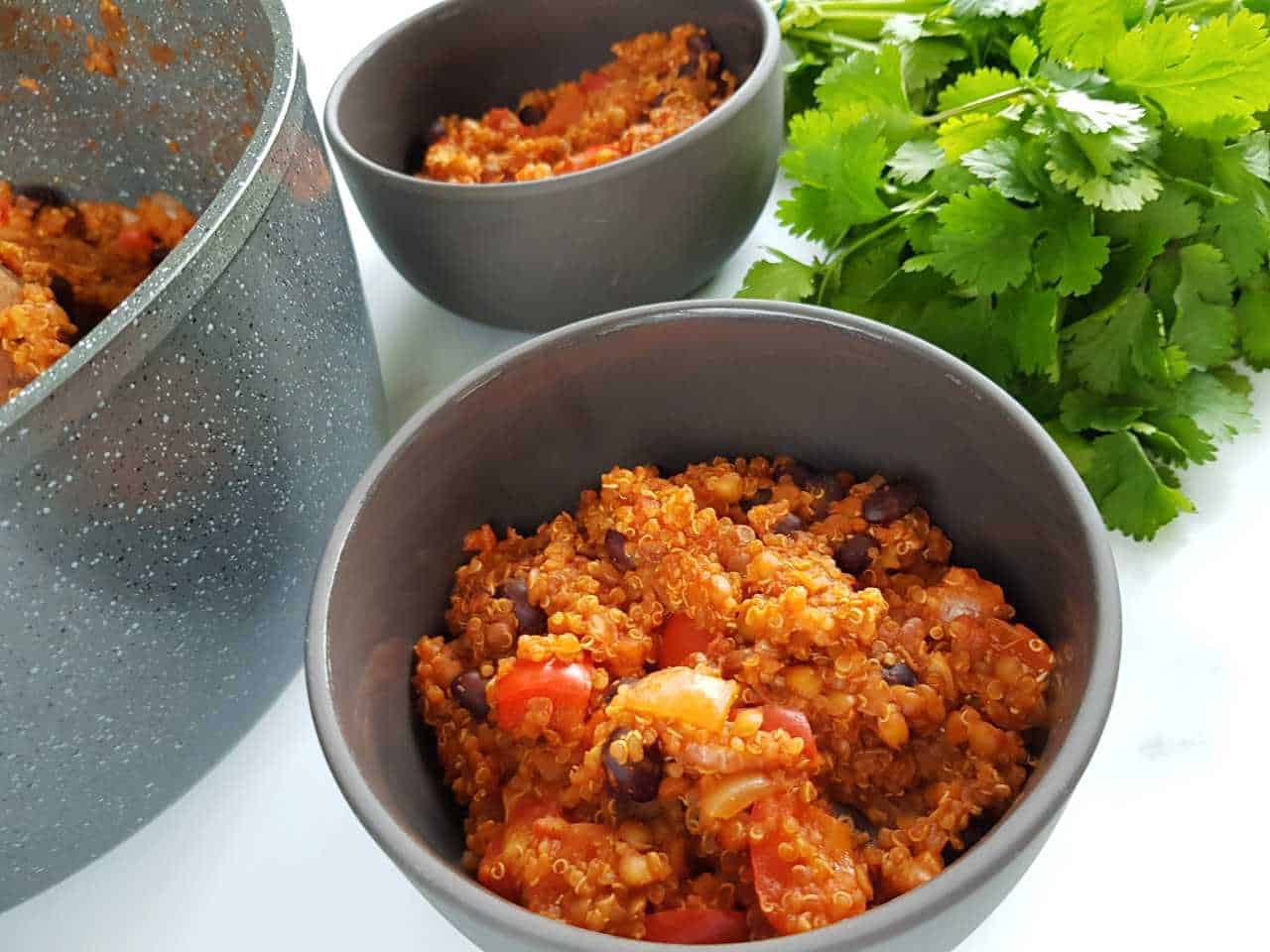 Vegetarian quinoa chili in gray bowls on a white table.