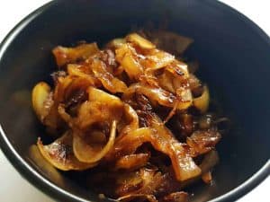 Caramelized onions in a black bowl.