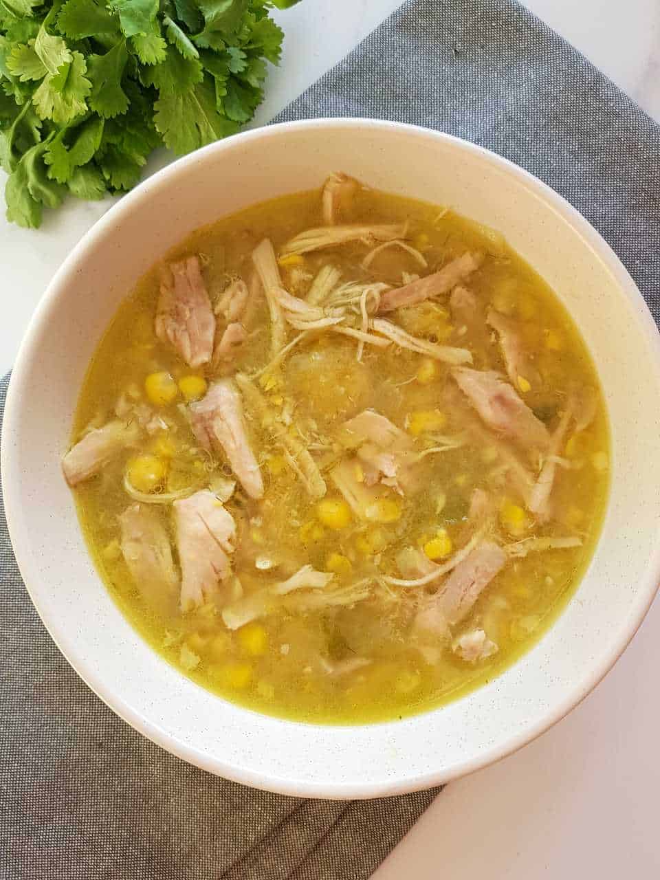 chicken and sweetcorn soup in a white bowl on a gray towel.