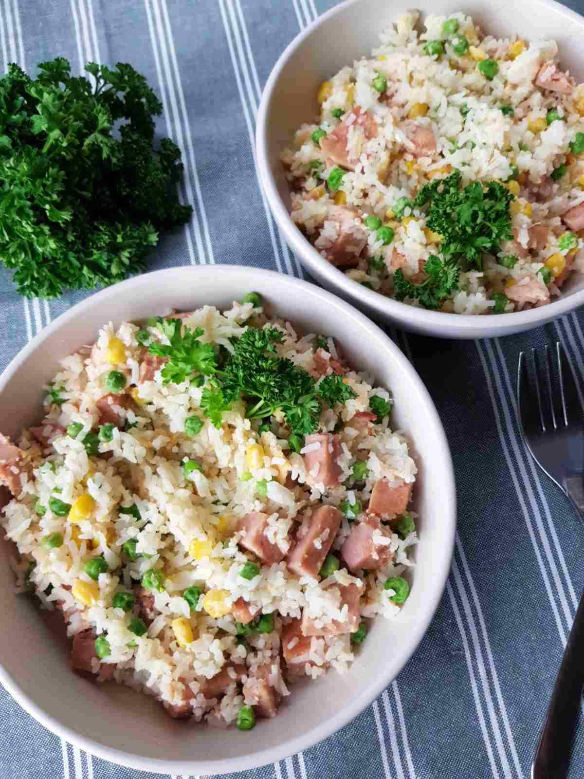 Gammon fried rice in white bowls on a tablecloth.