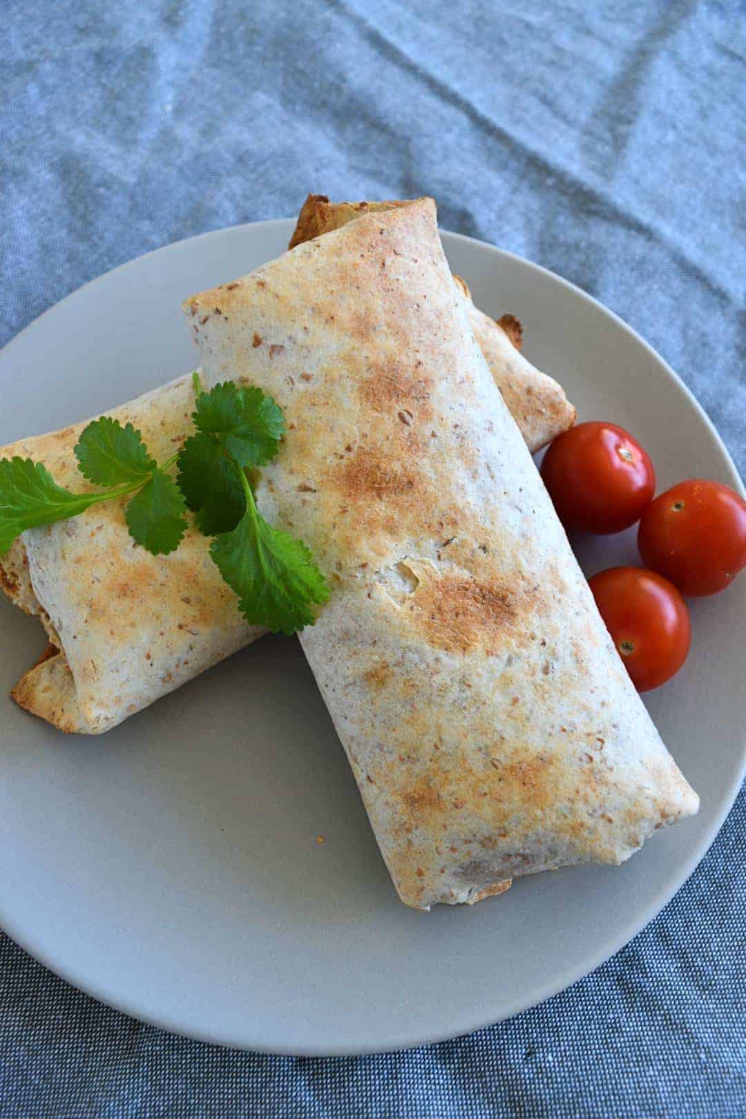 Air fried bean and cheese chimichangas on a plate.