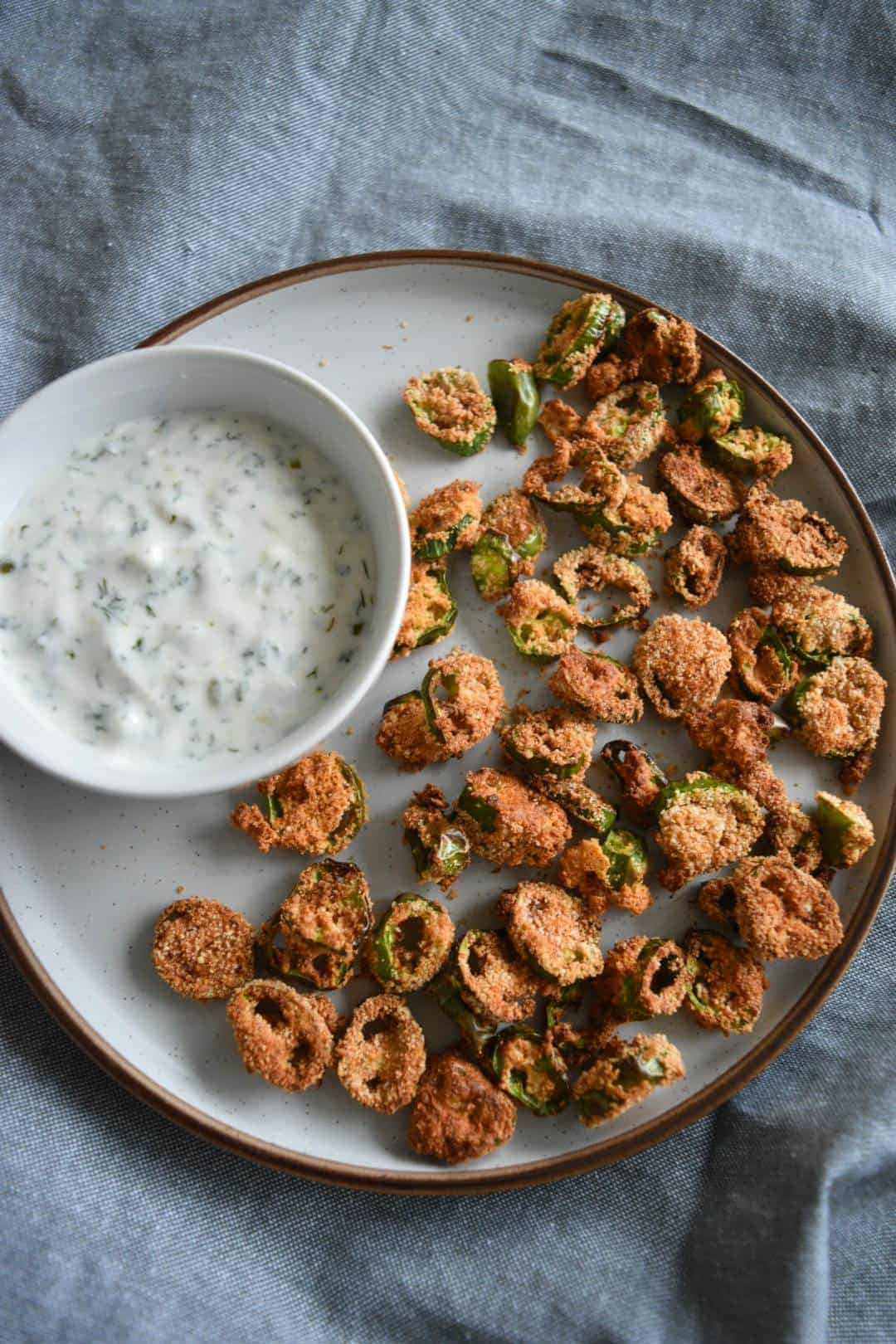 Jalapeno sliced on a plate with a side of ranch.