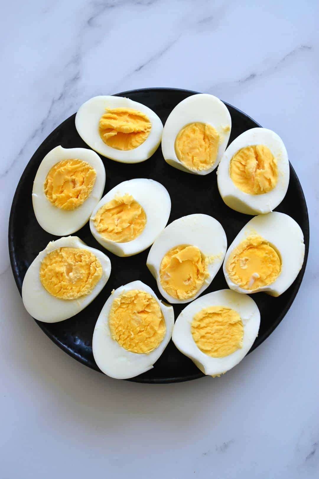 Hard boiled eggs on a plate on a marble table.