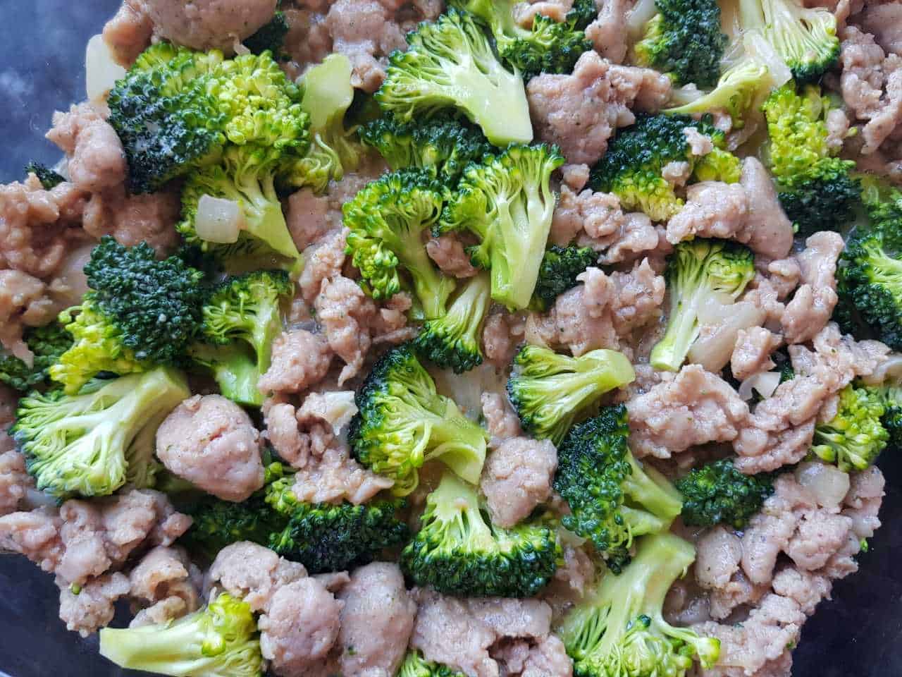 Sausage and broccoli in a casserole dish.