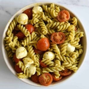 Caprese pasta pesto salad in a bowl.