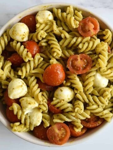 Caprese pasta pesto salad in a bowl.