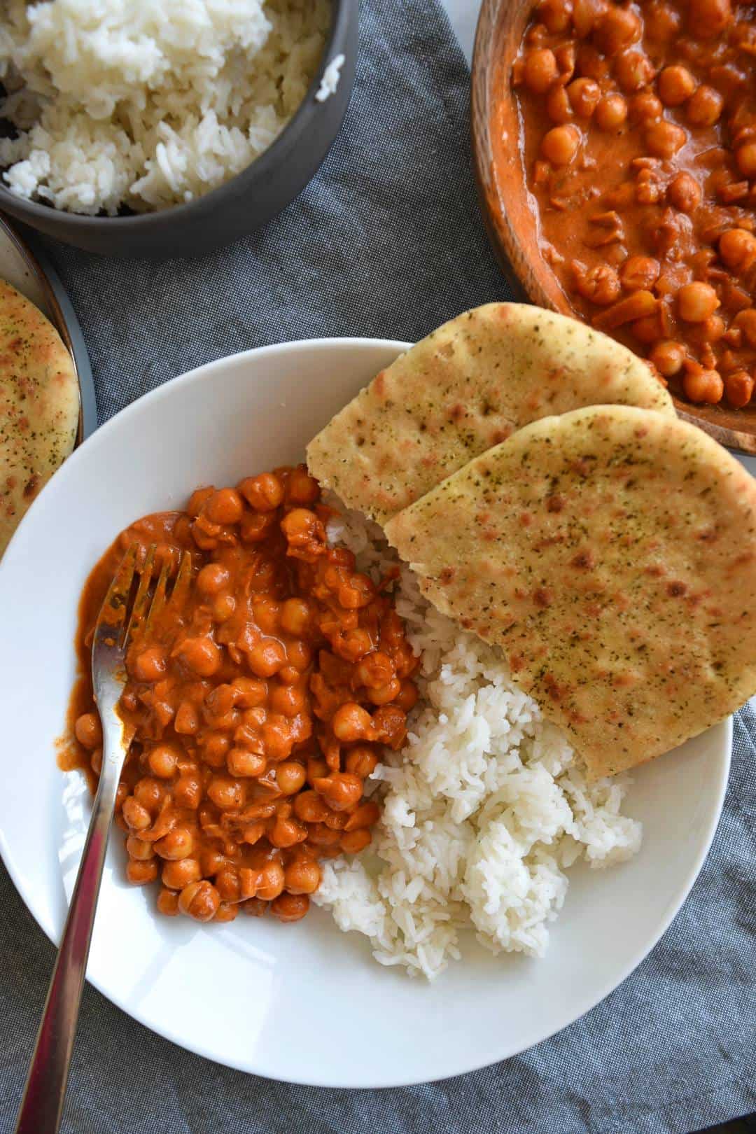 Chana masala, rice and naan bread in a bowl.