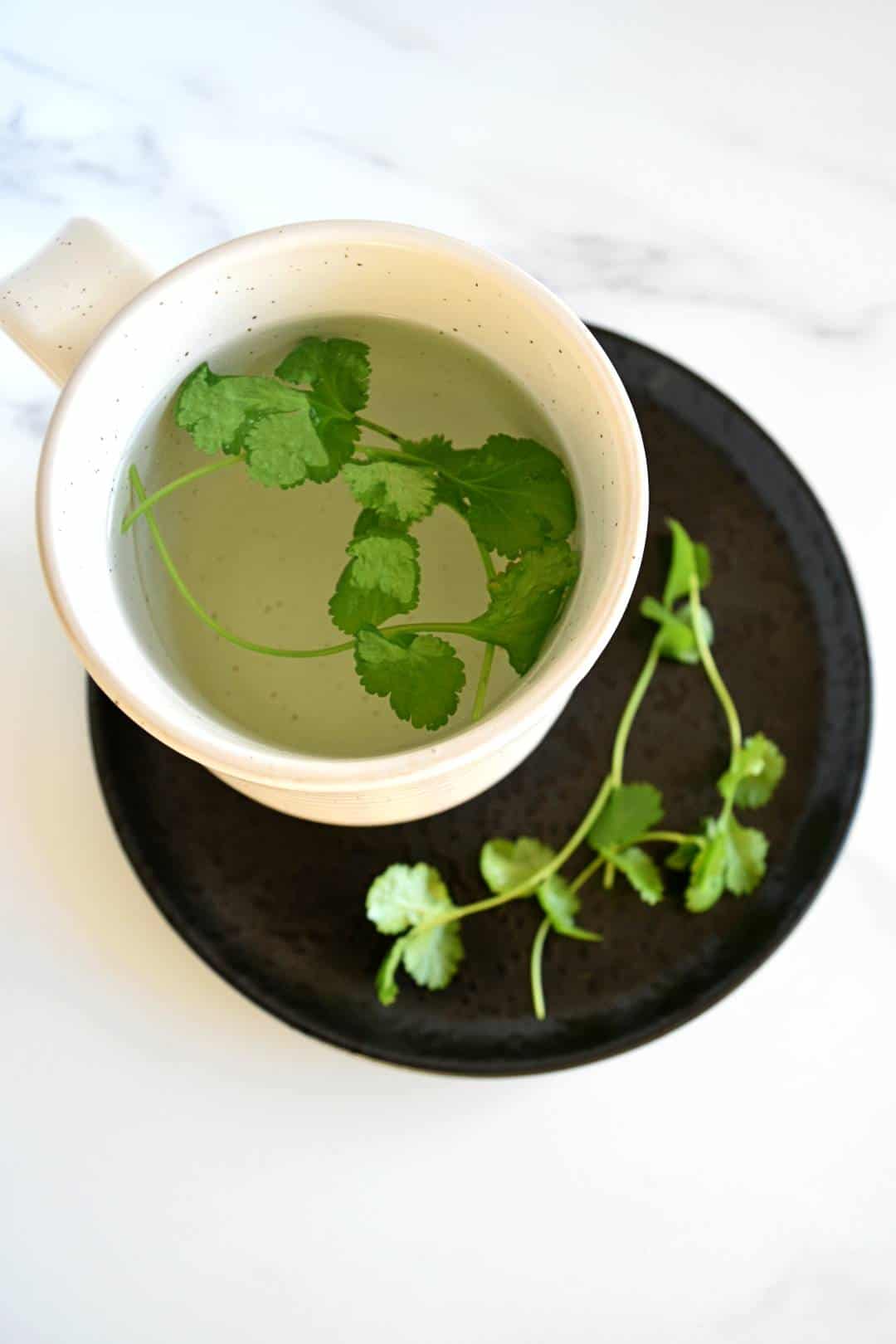 Cilantro tea steeping in a cup.