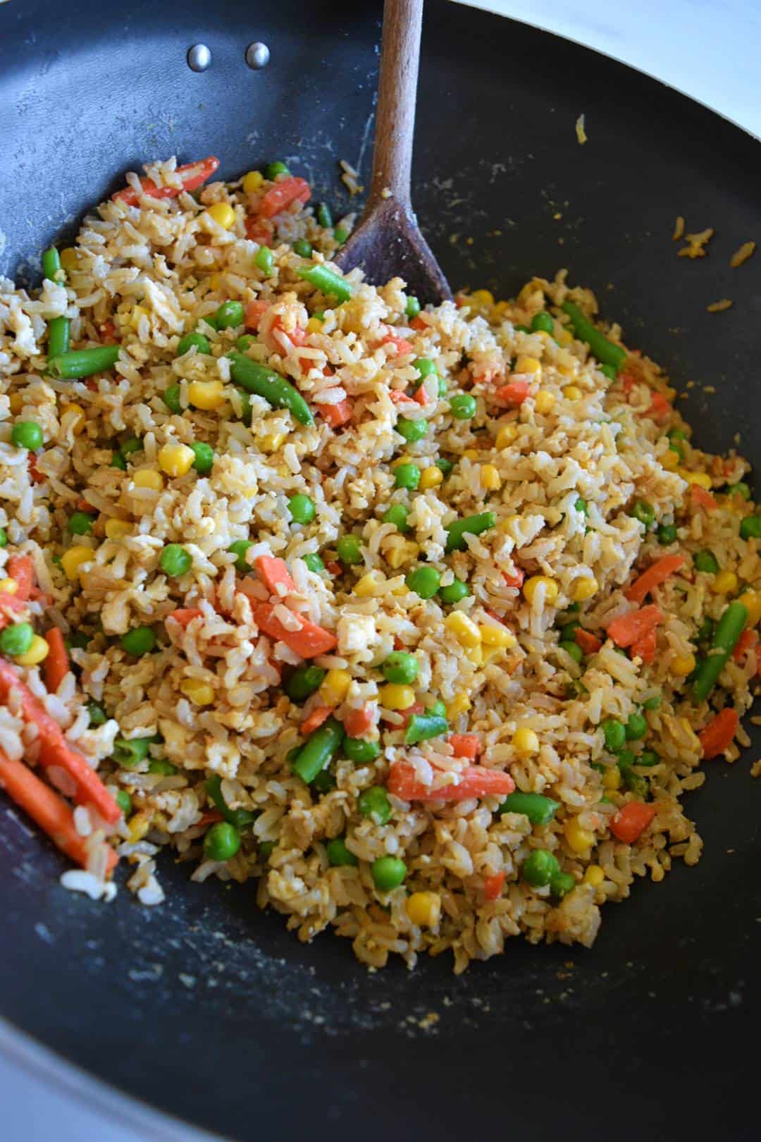 Egg fried brown rice in a wok.