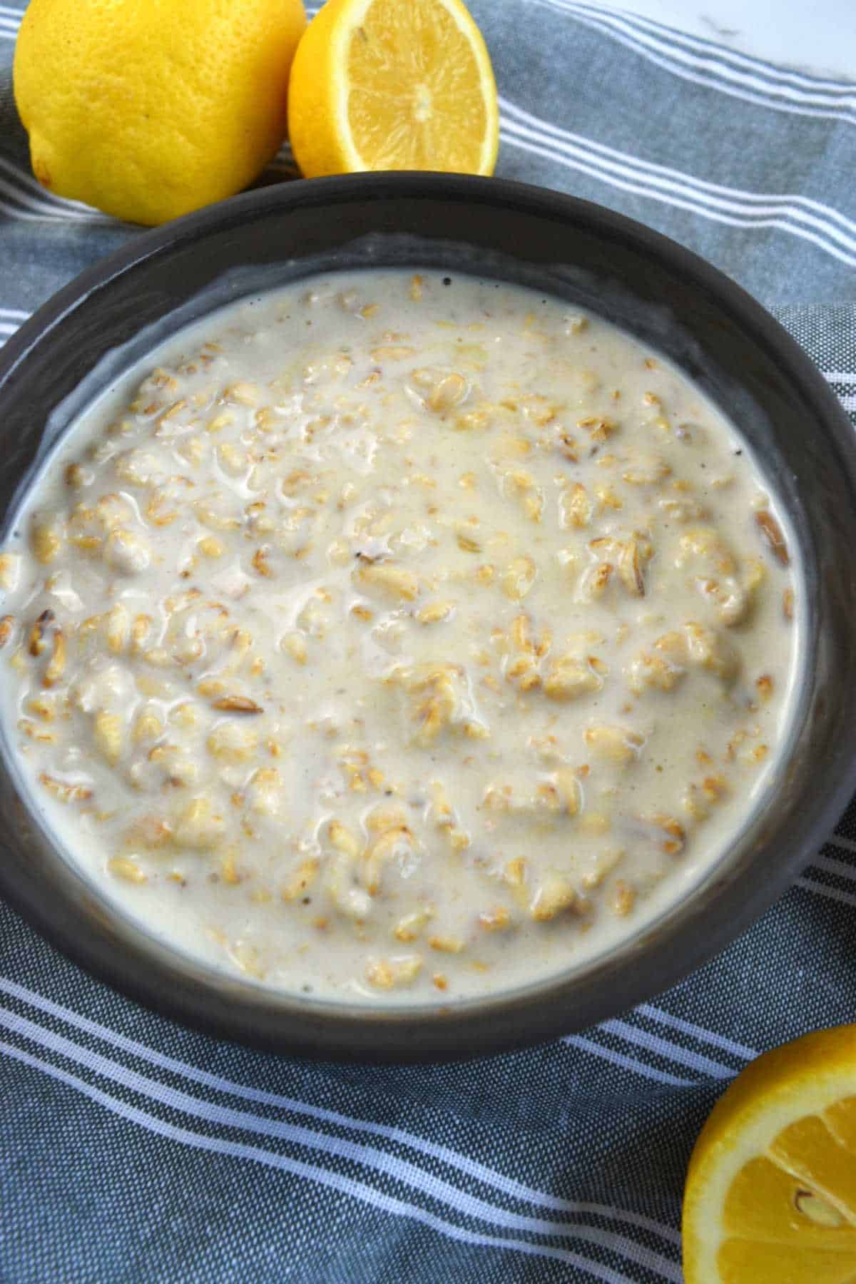 Lemon overnight oats in a bowl with lemons on the side.