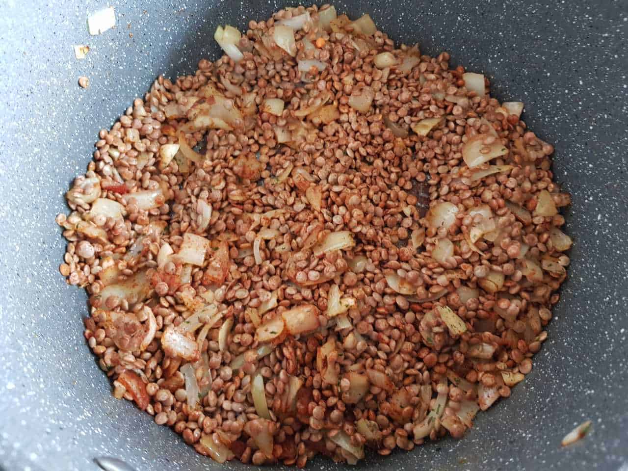 Lentils and onions cooking in a pot.