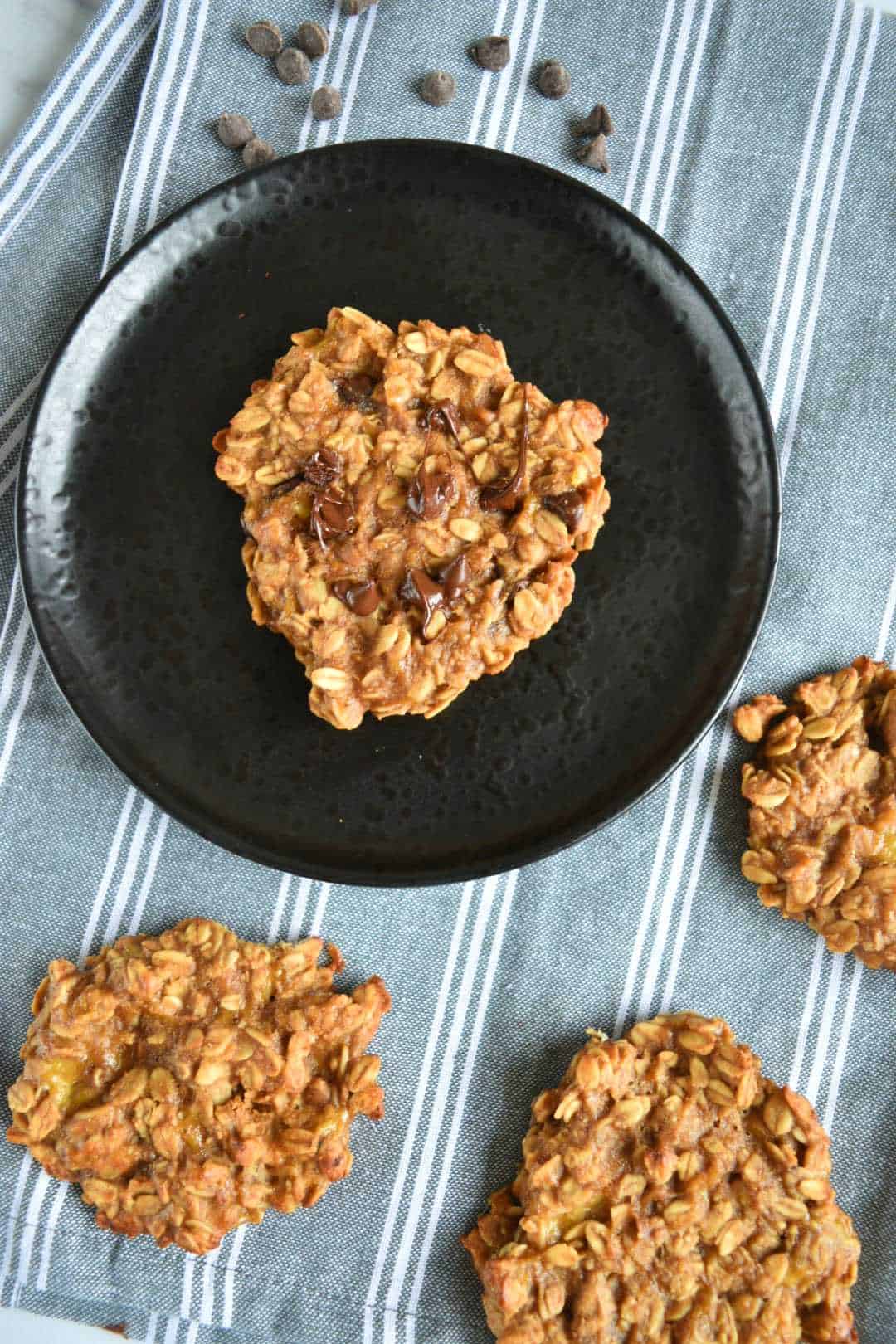 Chocolate chip peanut butter oatmeal cookie on a plate, surrounded by more cookies.