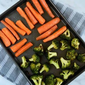 Roasted carrots and broccoli on a sheet pan.